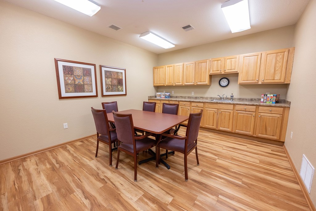 A kitchen with a table and chairs.