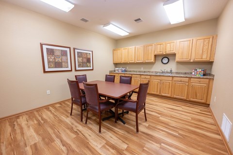 A kitchen with a table and chairs.