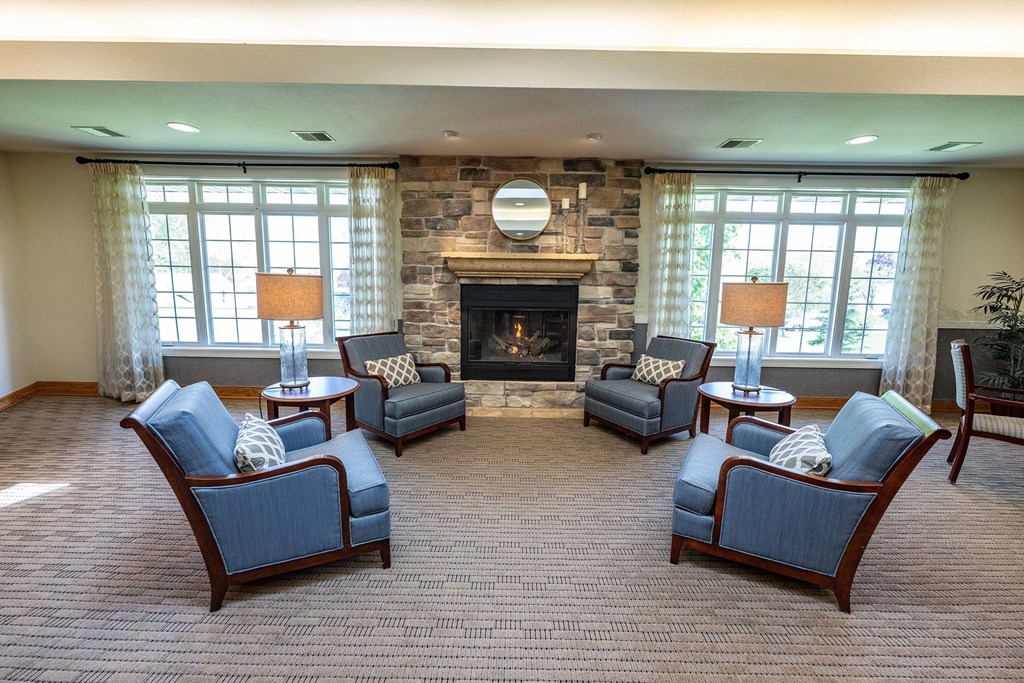 A living room with a fireplace and four chairs.