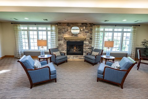 A living room with a fireplace and four chairs.