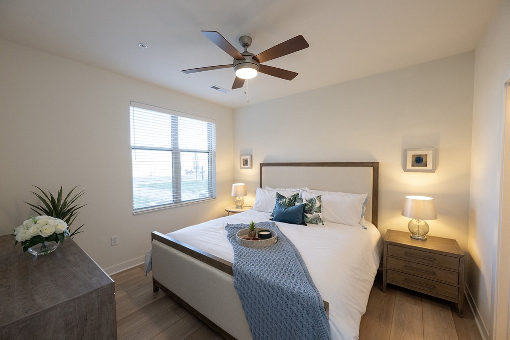 a bedroom with a large bed and a ceiling fan