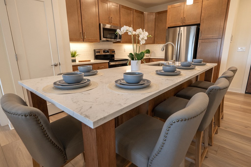 a kitchen with a marble table with plates and bowls on it
