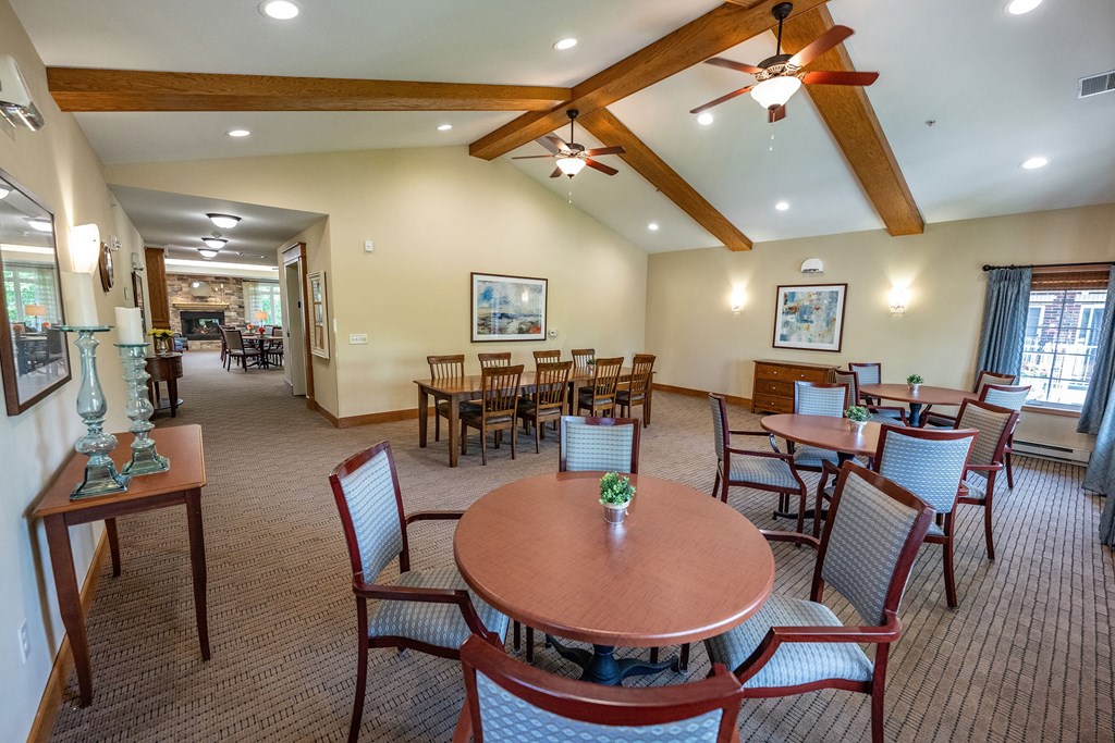 A room with a brown table and chairs and a ceiling fan.