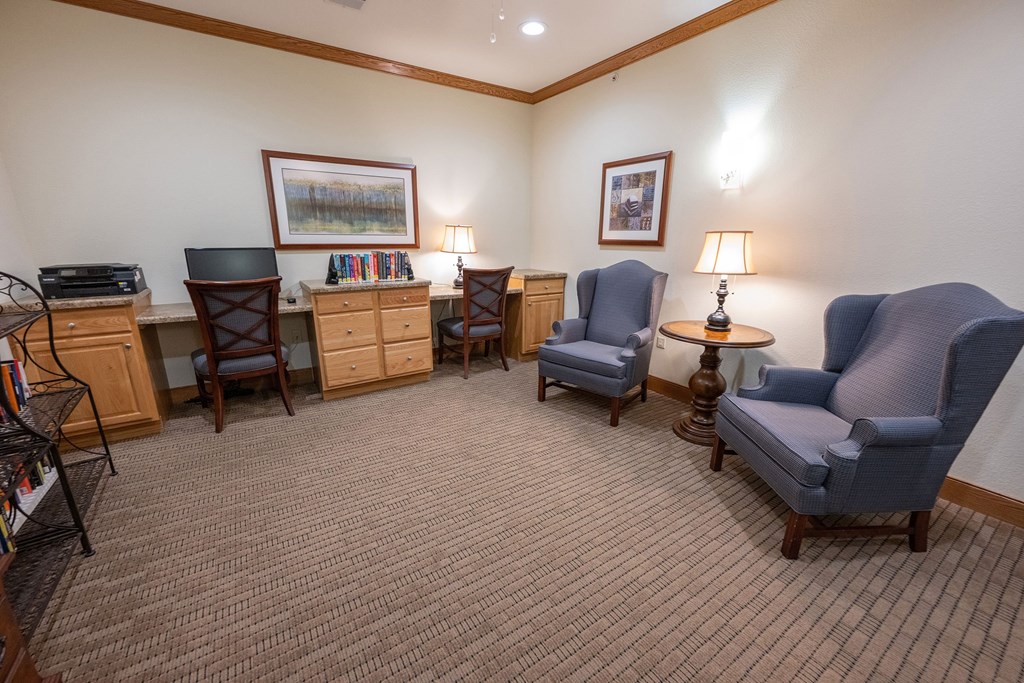 A room with a carpeted floor and a variety of chairs and tables.