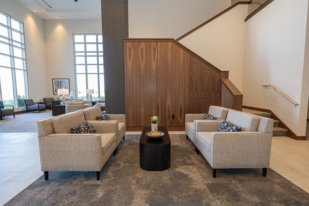 a living room with couches and a table in front of a staircase