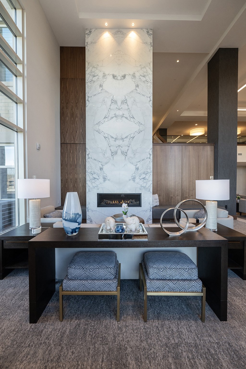 a living room with a desk and chairs and a fireplace