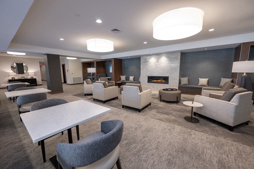 a lounge area with couches chairs and tables and a fireplace