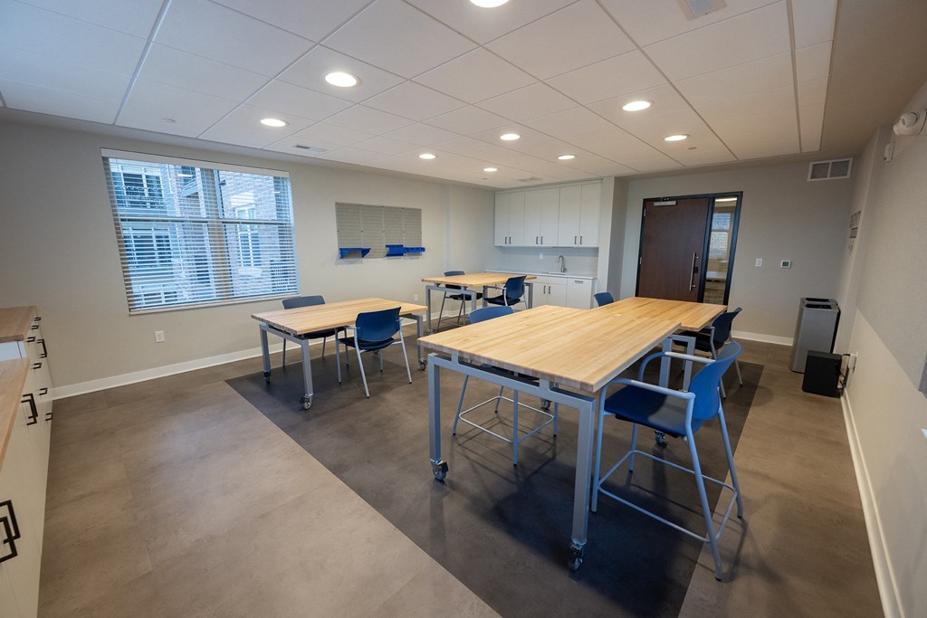 a dining room with tables and chairs and a kitchen
