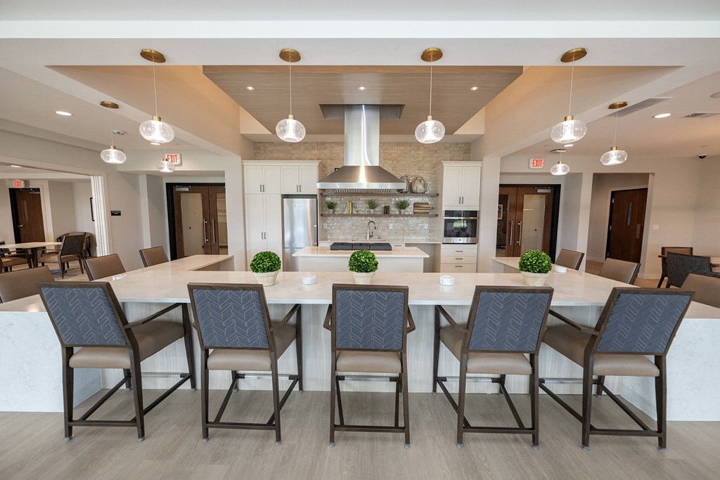 a large kitchen with a large island and chairs in front of a dining table