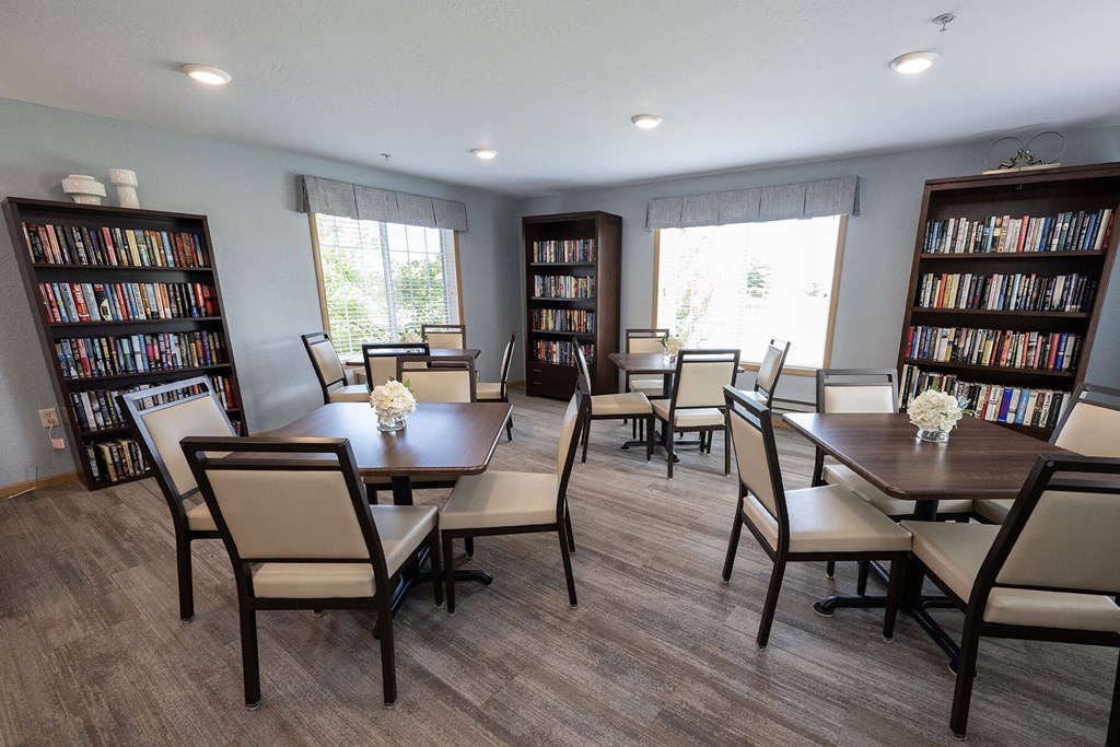 a dining room with a table and chairs and two bookcases with books