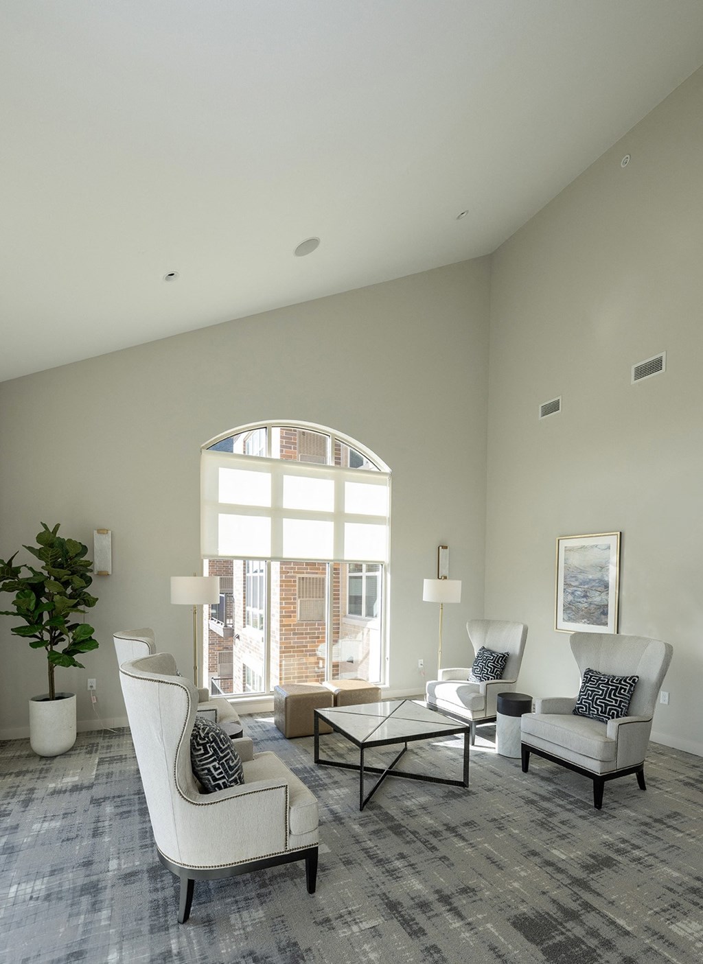 a living room with white furniture and a large window