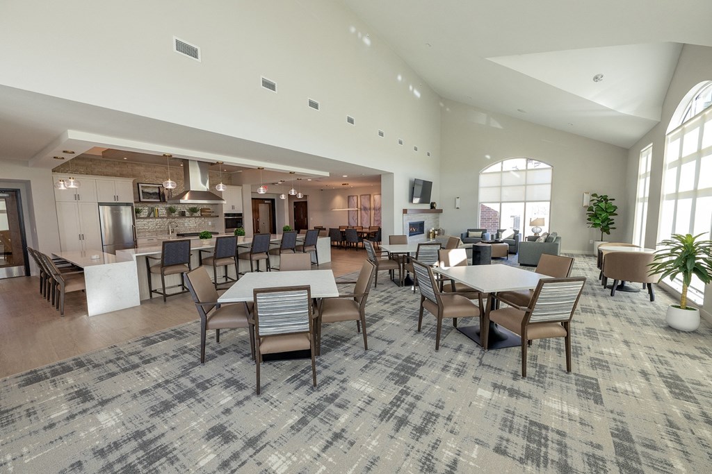 a large dining room with tables and chairs and a kitchen