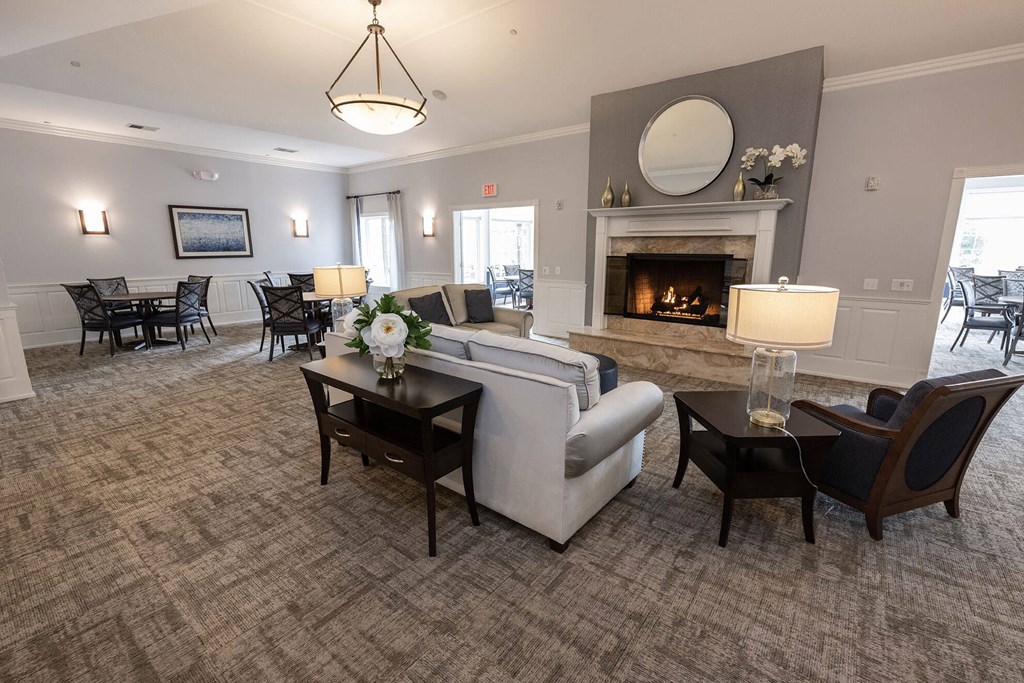 a living room with a fireplace and a dining room in the background