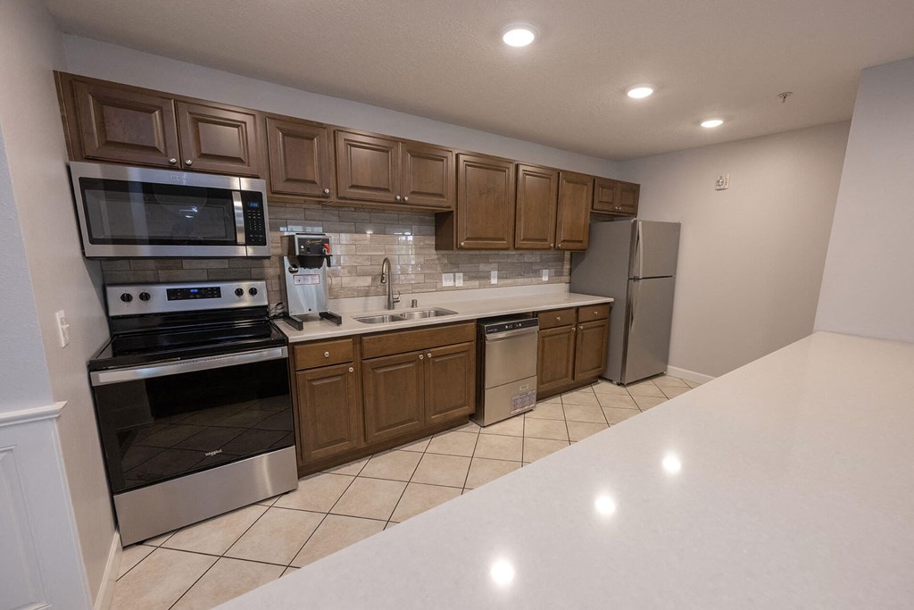 a kitchen with wooden cabinets and a white counter top