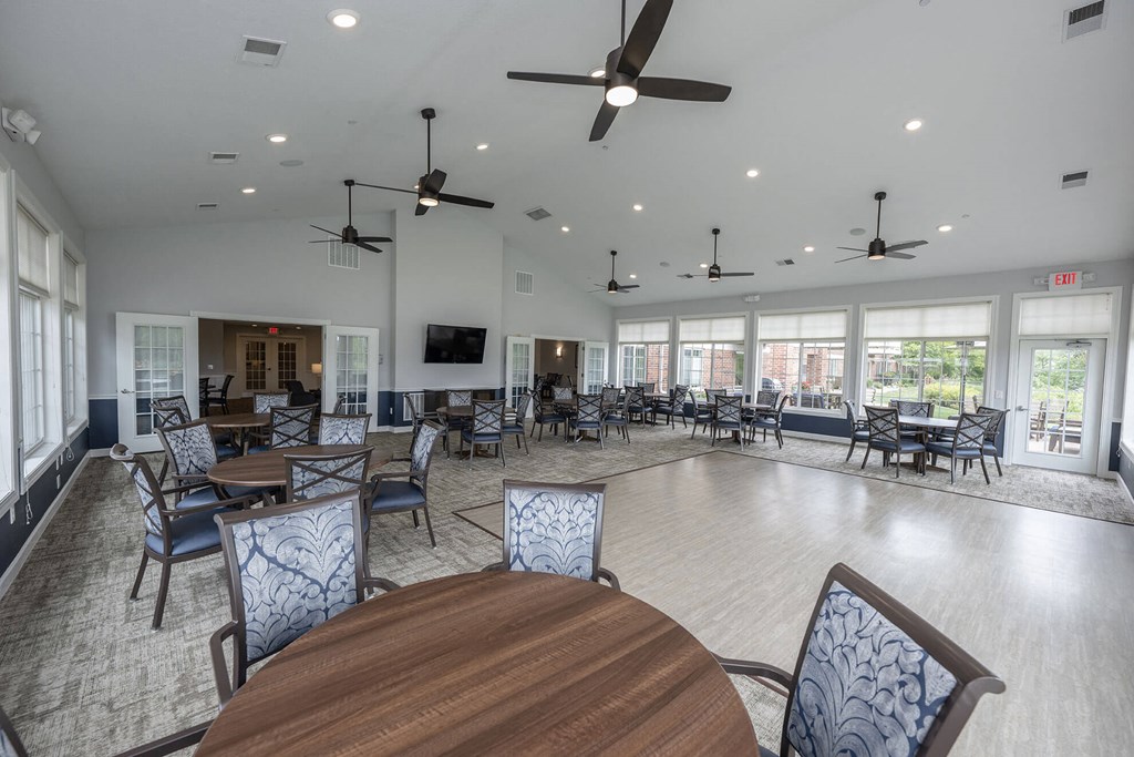 a large room with multiple ceiling fans and tables and chairs