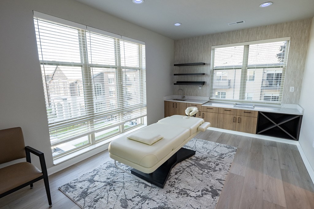 a spa room with a massage bed and a counter with two windows