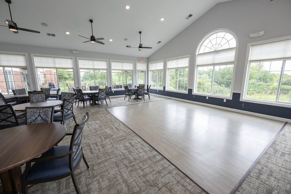 a large room with large windows and tables and chairs