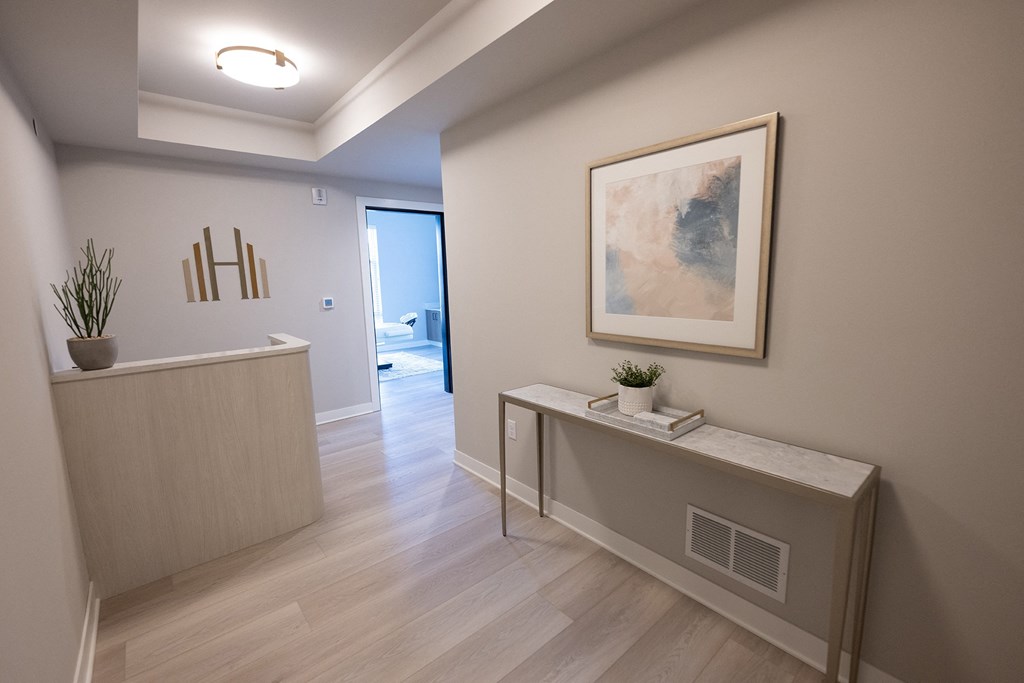 a hallway with a desk and a painting on the wall