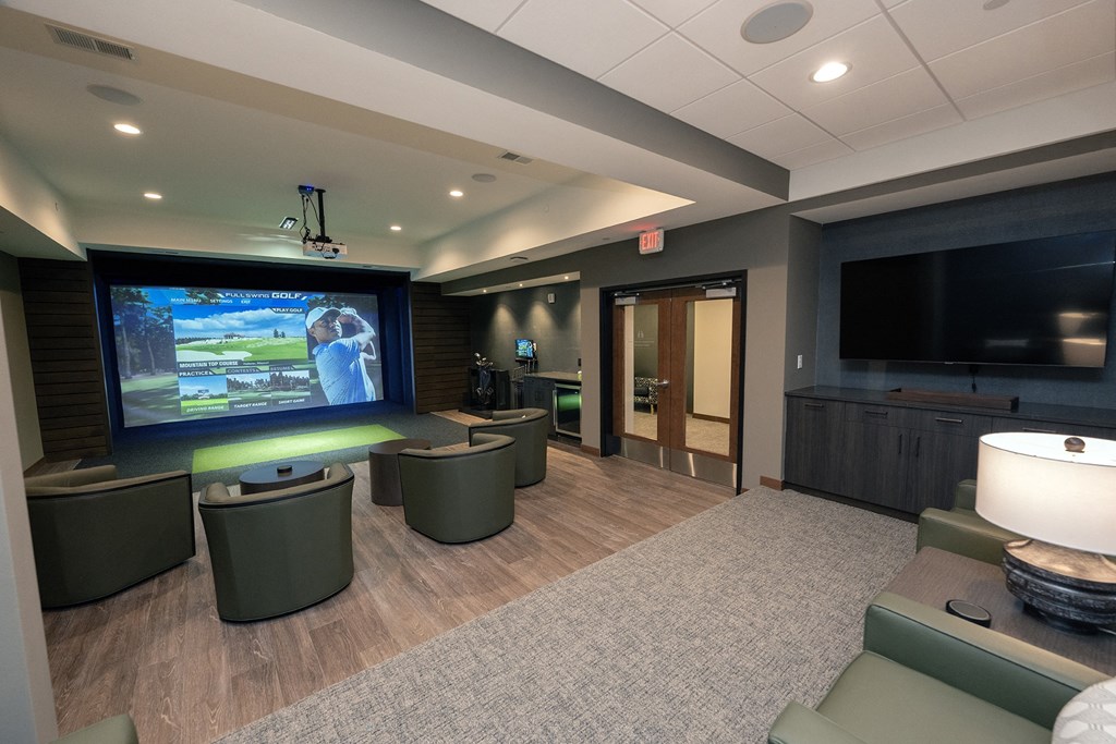 a community room with a large screen tv and couches