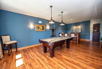 a game room with a pool table and chairs