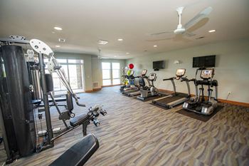 a home gym with exercise equipment and a ceiling fan