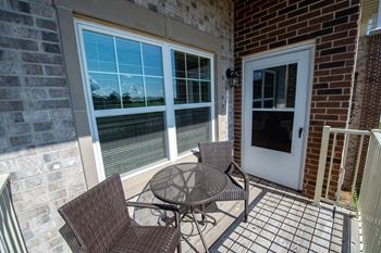 a patio with a table and chairs in front of a door