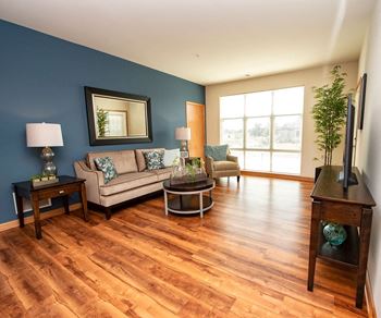 a living room with a blue accent wall and wooden floors