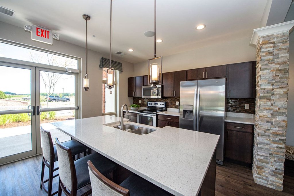 a kitchen with a large island and a stainless steel refrigerator