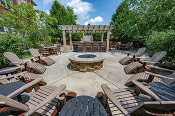 a patio with chairs and a fire pit
