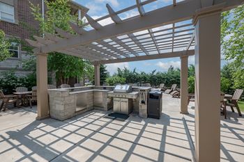 a patio with a grill and a pergola