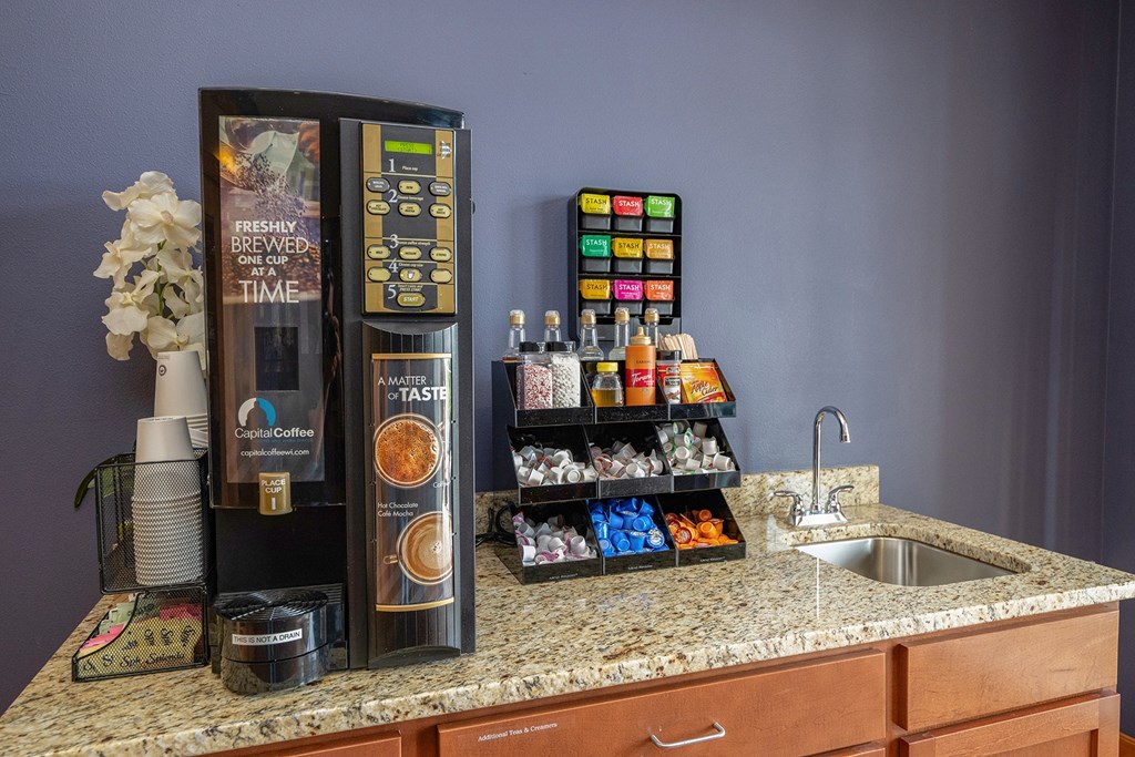 a kitchen counter with a refrigerator and a sink