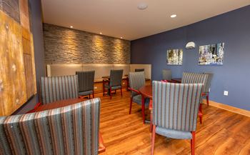 a dining room with a table and chairs and a stone wall