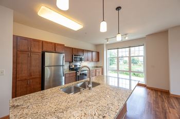 a kitchen with a granite counter top and a stainless steel refrigerator