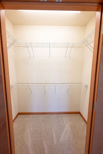 an empty closet in an empty room with white walls