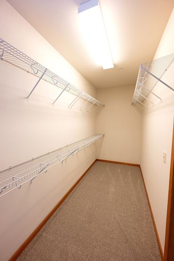 a spacious closet with shelves and a ceiling light