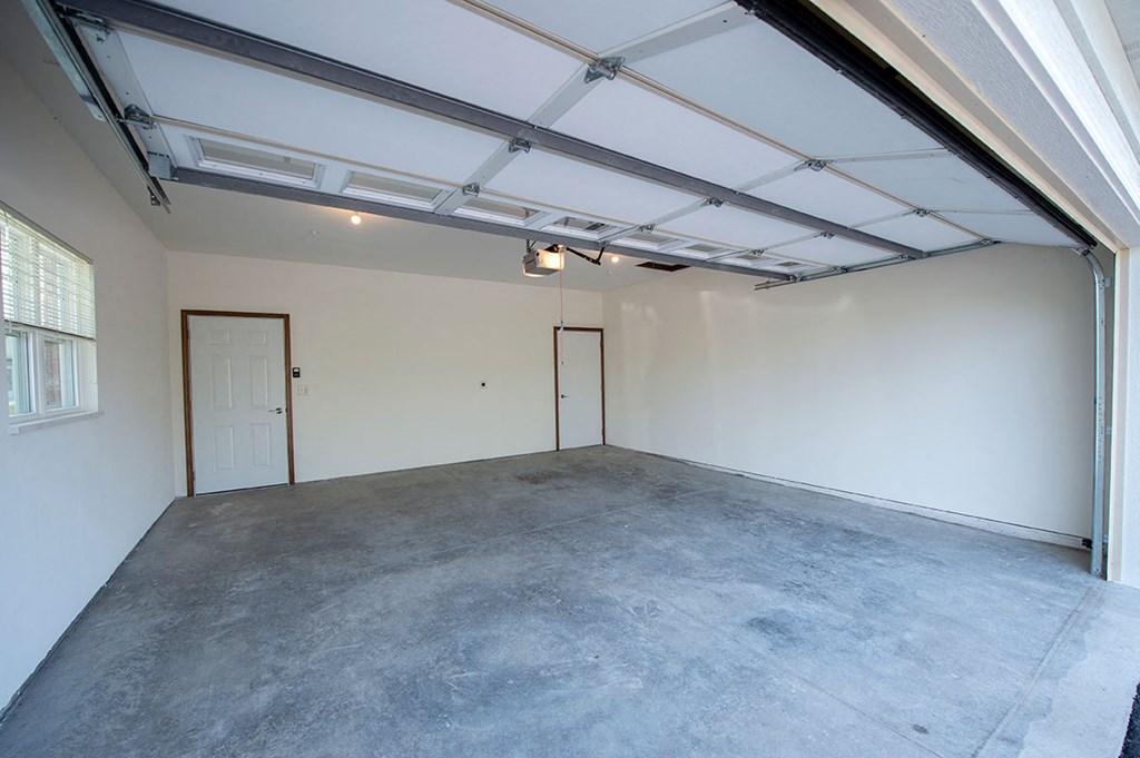 the interior of a garage with a concrete floor and a door