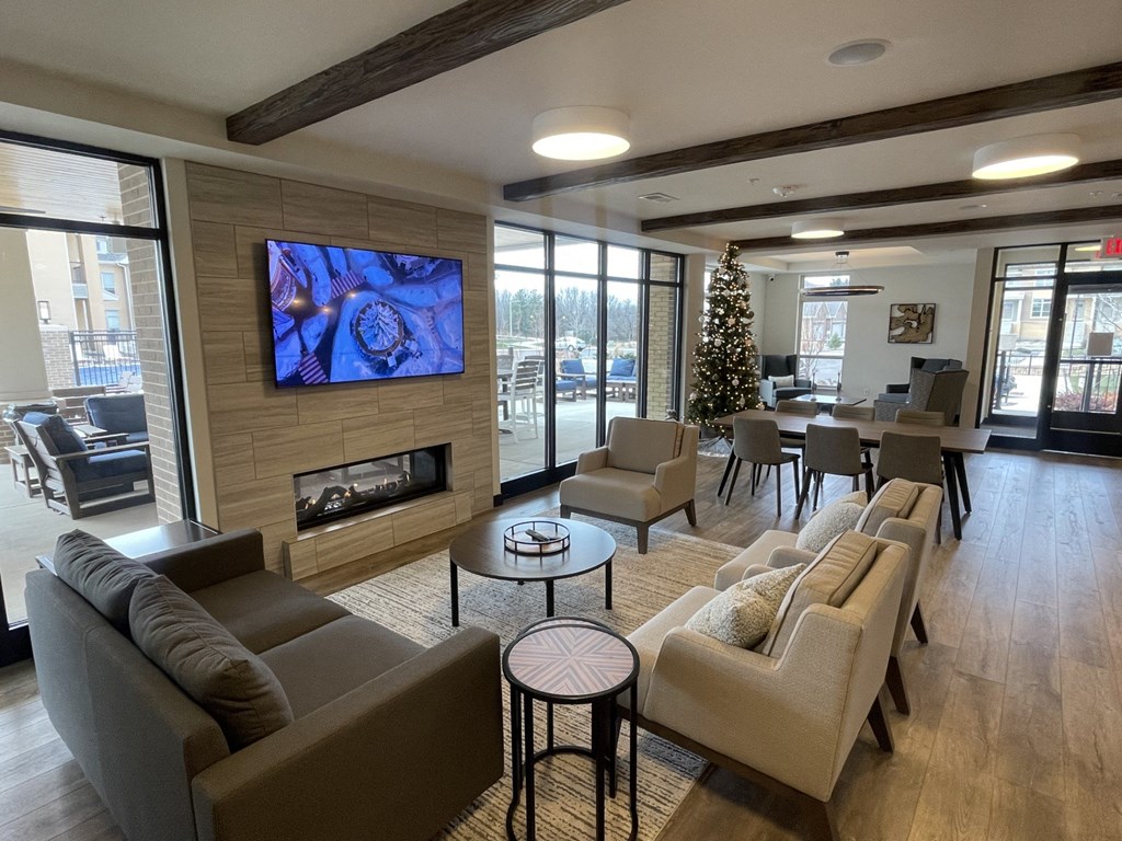 a living room with couches and chairs and a christmas tree