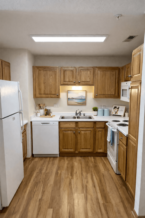 A kitchen with wooden cabinets and white appliances.