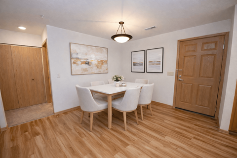 A dining room with a table and chairs.