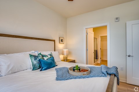 a bedroom with a large bed with pillows and a basket on it