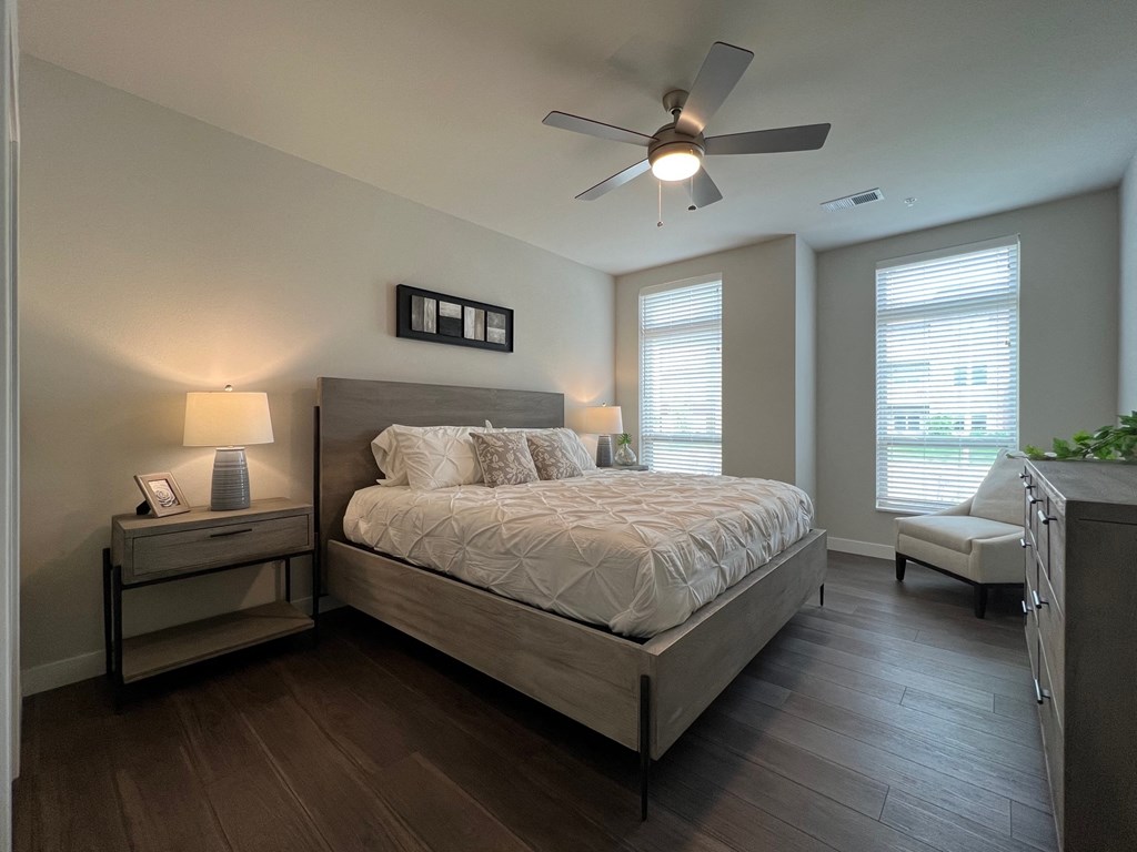 a bedroom with a bed and two windows