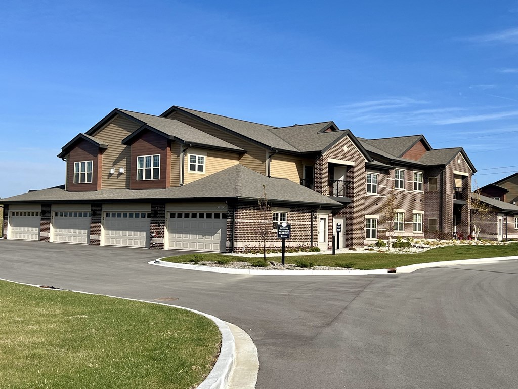 a large brick house with garage doors on a street