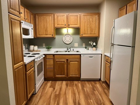 A kitchen with wooden cabinets and a white refrigerator.