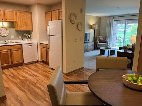 A kitchen with wooden floors and a white refrigerator.