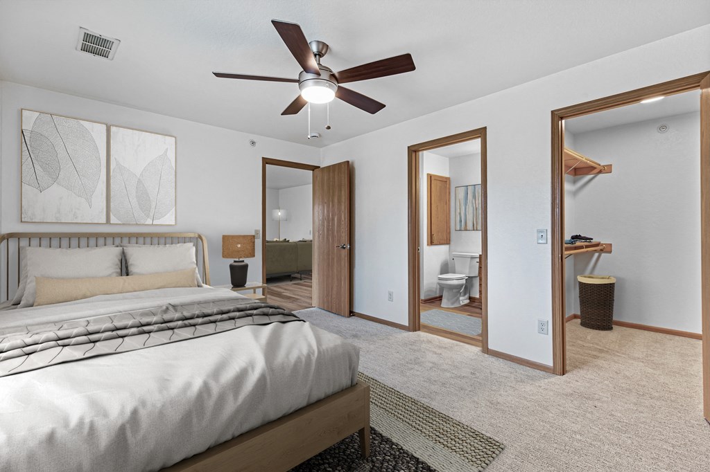 A bedroom with a large bed and a ceiling fan.