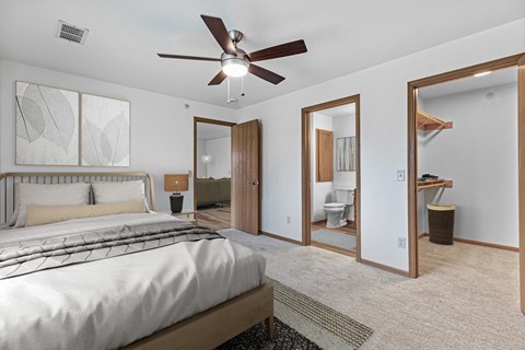 A bedroom with a large bed and a ceiling fan.