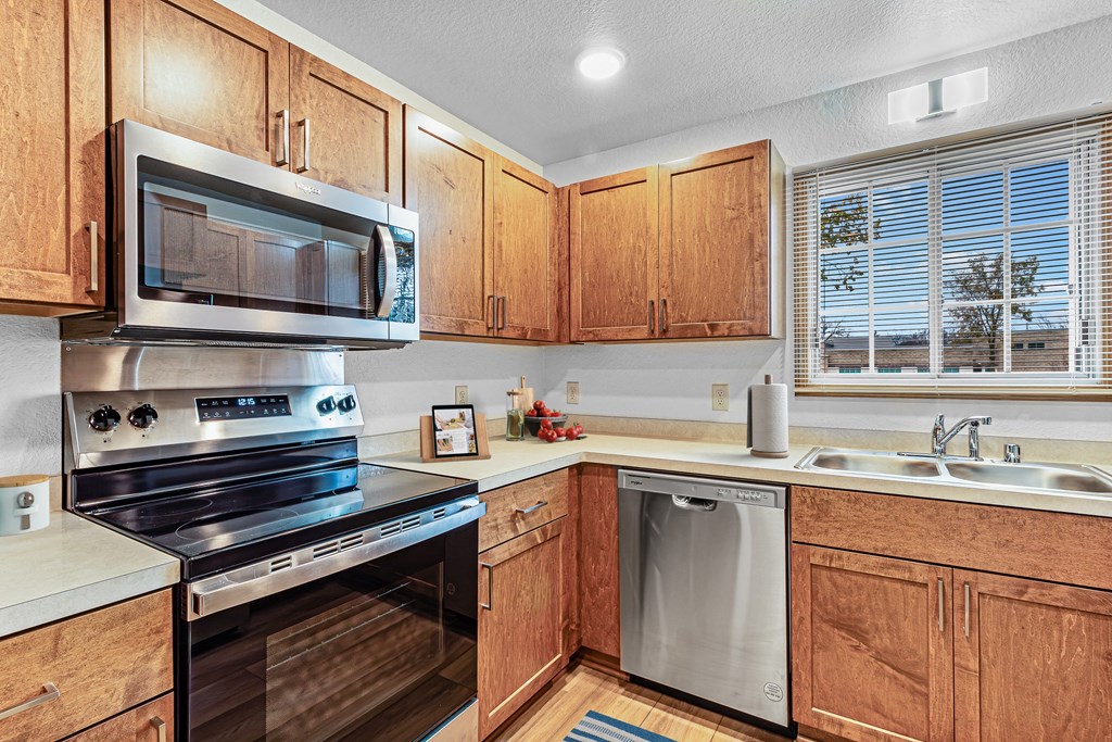 A kitchen with wooden cabinets and stainless steel appliances.