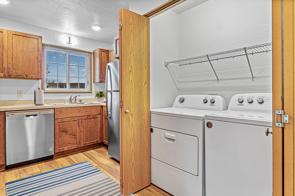 A kitchen with a refrigerator, dishwasher, and oven.