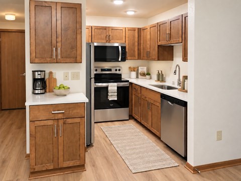 A kitchen with wooden cabinets and a white countertop.