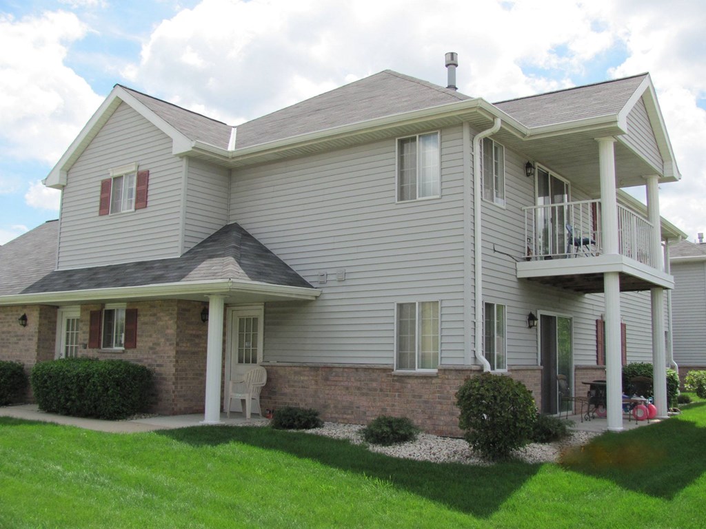 A house with a grey siding and a white porch.